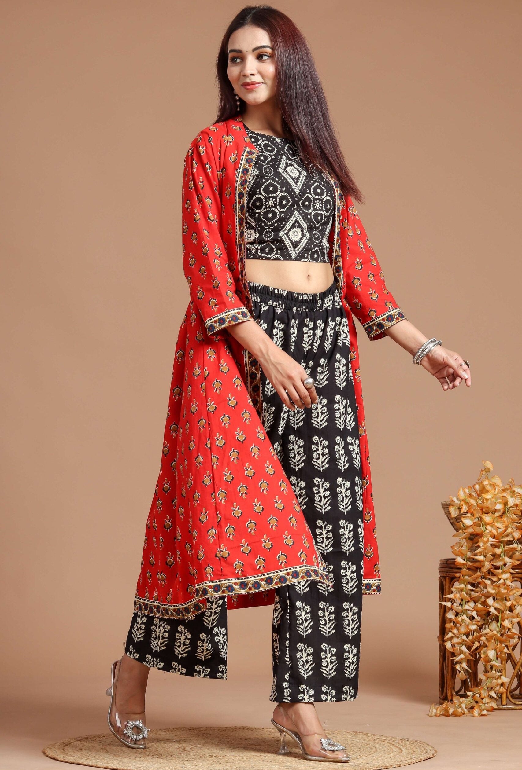 Woman wearing a red and black traditional outfit with a beige background